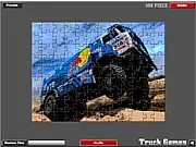 A close-up shot of a partially completed jigsaw puzzle on a screen, revealing the details of a red and blue Dakar Rally truck with large wheels.