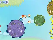 Screenshot of the Tiny Jumper online game, showing the small cartoon character jumping between colorful, rotating circular platforms to collect floating candies.