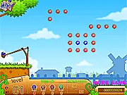 The Angry Birds style slingshot launcher in Hungry Mixy, showing the Mixy character ready to be launched toward piles of colorful candies high in the sky.