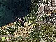 Monster Truck Jungle Challenge gameplay showing a large green off-road truck driving over rocks and trees in a forest environment, aiming a cannon at a distant bomb