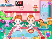 Baby Twin Trouble free online care game screenshot showing two cute baby twins, Anna and Peter, with various toys and food items