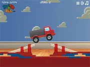 Toy Transporter game screenshot: a small toy truck driving through a colorful room, carrying various colorful toys.