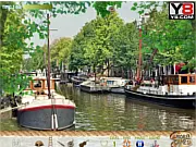 Screenshot of Amsterdam Hidden Objects game showing a detailed drawing of an Amsterdam canal scene with colorful buildings and a list of objects to find
