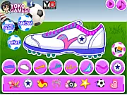 Screenshot from Decorate My Football Shoes game showing a brightly colored, customized soccer cleat with decorative patterns on the pitch