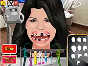 Screenshot from Selena's Perfect Smile dentist game showing an animation of Selena Gomez with dental tools being used to clean and repair her teeth. Play Selena Gomez Perfect Teeth online.