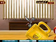 Play Bike Mania 4 Free Online, a miniature trials motorcycle racing game set on a desk with books and office supplies as obstacles.