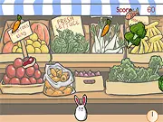 The main game screen of Veggie Mania, showing a colorful vegetable being thrown towards a hungry, infected rabbit on a bright green field.