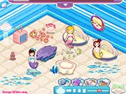 Gameplay screenshot of Ocean House showing a decorated coastal-themed living room with blue furniture, beach accessories, and large windows in the online interior design game.