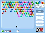 Marbles Shooter free online game screenshot showing a cannon aiming a colored marble at a ceiling of clustered, colored marbles