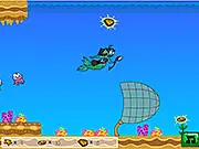 Screenshot of Ocean Bling free arcade game showing a small character collecting shells while avoiding large fish in the deep blue sea