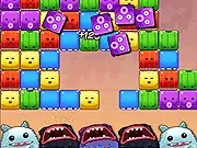 Screenshot of the Pop'Em Up game showing colorful square blocks of food on a grid with small, cute monsters waiting at the bottom.