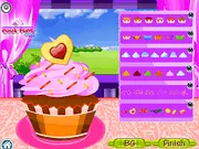 Cupcake Deco game screenshot showing a brightly decorated vanilla cupcake topped with pink frosting, colorful sprinkles, and a small strawberry