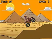 The gameplay screen of Tutankamoto Moto Ride, showing a motorcyclist balancing a bike over steep, sandy hills with an ancient Egyptian pyramid in the background