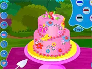 Spring Cake Decoration free online game showing a beautifully designed two-tier cake adorned with flowers, candies, and chocolate.