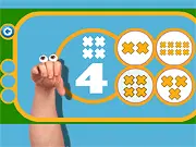 Screenshot of the Oobi: Numbers game showing colorful objects on the screen and the character Oobi helping a child learn to count and match numbers.