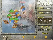 The Glass Works game board showing a puzzle grid partially filled with colorful glass pieces, with a trash bin option visible