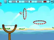 Screenshot of a football being launched by a slingshot, aiming to pass through a series of red rings in the free online physics puzzle game Slingshot Football Fun