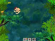 The Jungle Boy character jumping up a tree to collect yellow fruits in the free online game