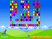 A cannon firing a ball at a cluster of balloons and obstacles in the free online physics puzzle game Canoon Ball Shooter