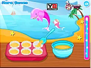 Screenshot of the free online cooking game Smarties Muffins On Top showing a tray of freshly baked muffins being decorated with colorful Smarties candies.